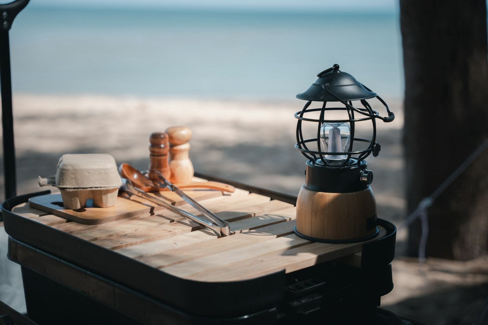 Camping essentials, a vintage kerosene lamp and a modern LED lantern on a wooden table. Enjoy nature